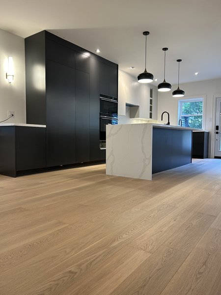 Open concept kitchen with dark cabinetry and hardwood floors GTA
